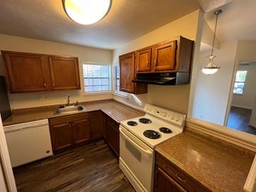 Arlington house for rent - A kitchen with a white stove top oven and wooden cabinets.