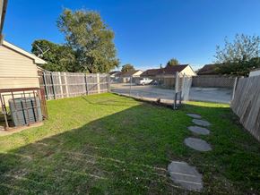 Arlington house for rent - A backyard with a fence, a pathway, and a grassy area.