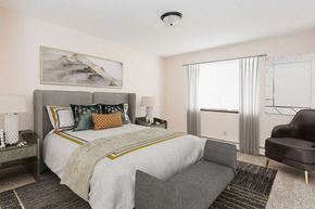 Stillwater apartment for rent - a bedroom with a bed and a chair and a window