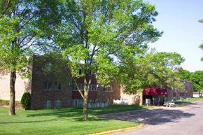 Stillwater apartment for rent - a large brick building with trees in front of it