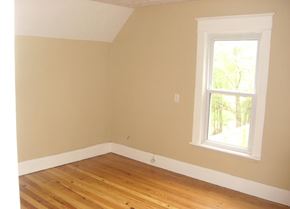 South Bend house for rent - A room with a window and wooden floors.