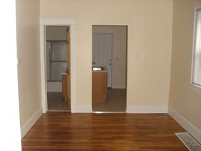 South Bend house for rent - A room with a wooden floor and a white door.