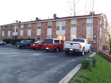 Riverside apartment for rent - a large brick building with cars parked in front
