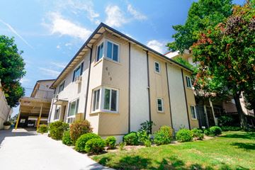Burbank apartment for rent - A beige two-story house with a well-maintained lawn and trees in the background.