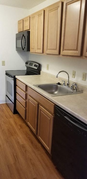 Saint Charles apartment for rent - A kitchen with wooden cabinets and black appliances.