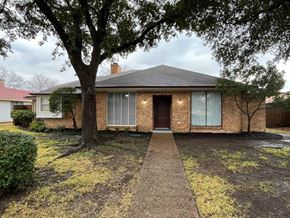 Richardson house for rent - A house with a brick facade and a tree in front.