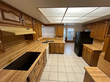 Richardson house for rent - A kitchen with wooden cabinets and black appliances.