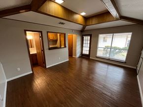 Richardson house for rent - A room with wooden floors and a large window.