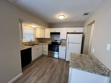 Dallas house for rent - A kitchen with a granite counter top and white appliances.