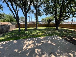 Mesquite house for rent - A backyard with a sand pit and trees.