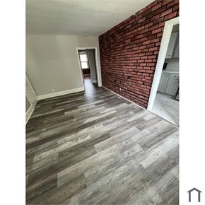 Baltimore apartment for rent - a living room with wood floors and a brick wall