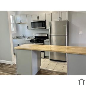 Baltimore house for rent - A kitchen with a stove, refrigerator, and cabinets.