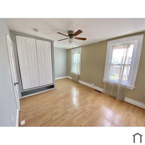 Baltimore house for rent - A room with a ceiling fan and a sliding door.