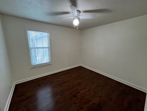 Dallas house for rent - an empty bedroom with a ceiling fan and a window