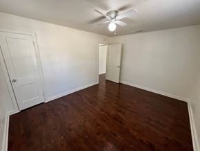 Dallas house for rent - an empty living room with wood flooring and a ceiling fan