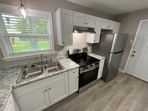 Mesquite house for rent - A kitchen with a sink, stove, and refrigerator.