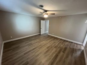 Dallas house for rent - A room with a ceiling fan and wooden flooring.