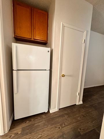 Austin apartment for rent - A white refrigerator is in a kitchen next to a white door.