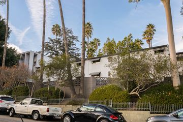 Los Angeles apartment for rent - an apartment building with palm trees and cars parked in front