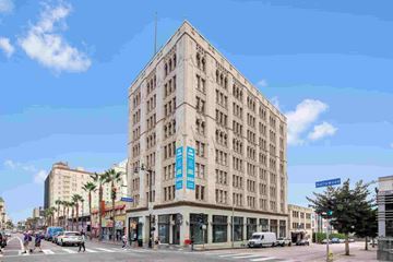 Hollywood apartment for rent - a large white building with a blue sign on the corner of a city street