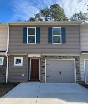 Fayetteville house for rent - a tan house with a garage door in front of it
