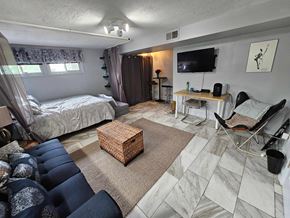Washington apartment for rent - A bedroom with a bed, chair, and a television.