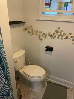 Washington apartment for rent - A white toilet in a bathroom with a green and blue shower curtain.