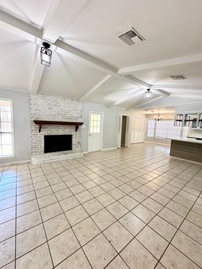 Lafayette house for rent - a large living room with a fireplace and tile flooring