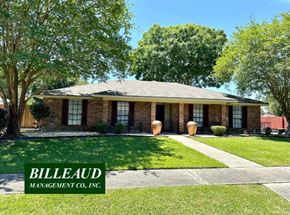 Lafayette house for rent - a small brick house with a lawn and trees