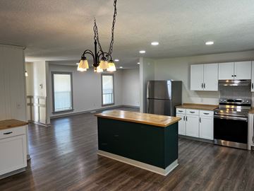 Fort Valley house for rent - a kitchen with white cabinets and a black counter top