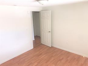 Bradenton house for rent - a bedroom with a wooden floor and a white door