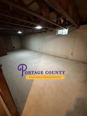 Stevens Point apartment for rent - An empty room with Portage County Property Management logo.