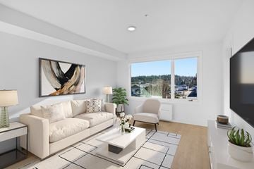 Qualicum Beach apartment for rent - A modern living room with a large painting on the wall and a view of the outdoors through the windows.
