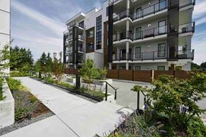 Qualicum Beach apartment for rent - A modern apartment building with a walkway in front of it.