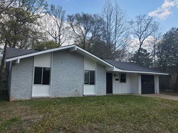 Leesville house for rent - A house with a grey brick exterior and a white door.