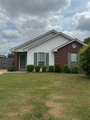 Montgomery house for rent - a white house with green shutters and a grass yard