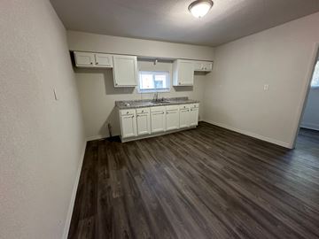 Lima house for rent - A kitchen with white cabinets and a window.
