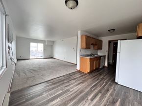 Grand Forks apartment for rent - an empty living room and kitchen with wood flooring and white walls