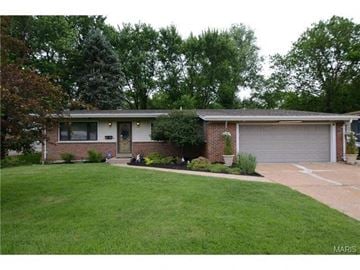 Florissant house for rent - a brick house with a yard and a garage door