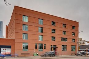 Edmonton apartment for rent - A red building with a sign that says "For Sale" on the left side.
