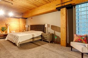 Edmonton apartment for rent - A bedroom with a bed, nightstand, and chair.