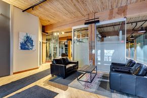 Edmonton apartment for rent - A modern living room with a black couch and a wooden ceiling.