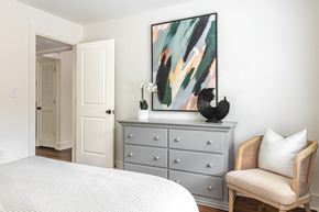 Atlanta apartment for rent - a bedroom with a bed and a dresser with a painting on it