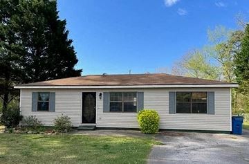Anniston house for rent - a small white house with a driveway and trees
