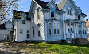 Monmouth apartment for rent - A large white house with blue trim and a black roof.