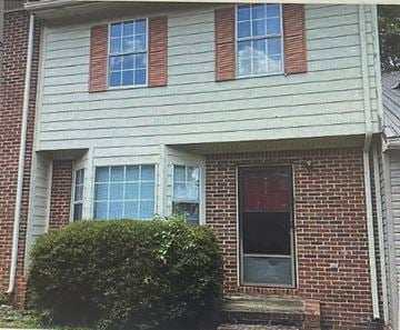 Anniston house for rent - the front of a brick house with a door and windows