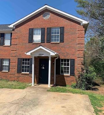 Anniston house for rent - a brick house with a black door and black windows