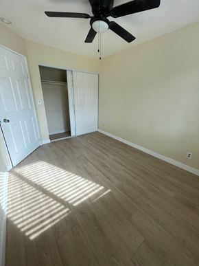 San Diego apartment for rent - A room with a ceiling fan and light, and a wooden floor.