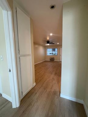 San Diego apartment for rent - A long hallway with a door on the left and a window on the right.