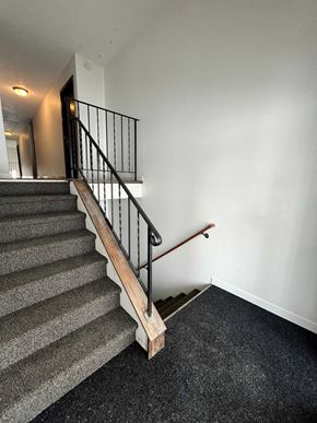 Grand Forks apartment for rent - a stairwell in a home with a railing and carpeted stairs